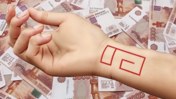 Forearm with a red geometric outline (rectangular shapes) drawn or tattooed, resting over a spread of banknotes in the background.